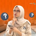 Wanita berhijab sedang memegang ponsel dan berpikir memilih sewa mobil Lombok